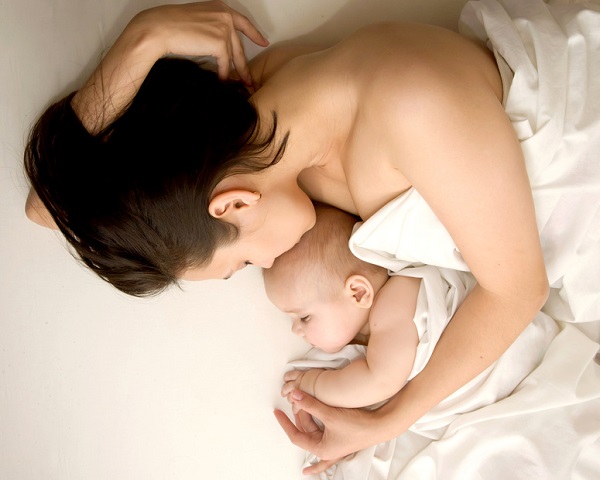 Newborn baby sleeping with mother. Tenderness and love
